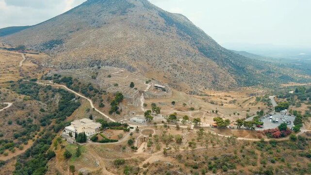Mycenae, Greece. The ancient citadel and its Cyclopean walls, aerial panoramic view over the Bronze Age acropolis and surrounding Argolid landscape. Drone footage, Point of interest