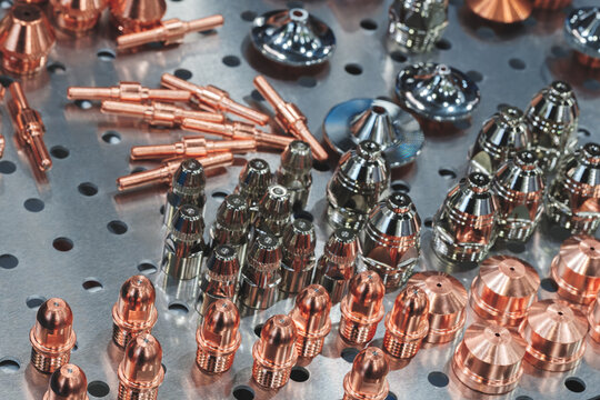 Copper and silver plated metal parts for welding equipment are arranged on perforated sheet. tech industrial technology background
