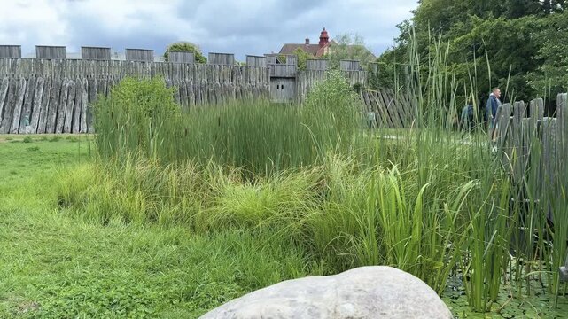 Rune stone and wooden palisade at the Trelleborgen viking fortress