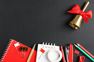 Different school stationery and bell on blackboard, flat lay. Space for text © New Africa