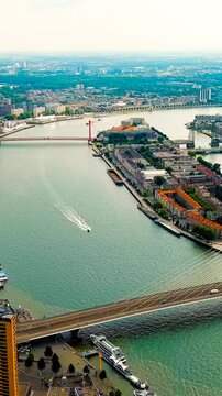 Vertical video. Rotterdam, Netherlands. Erasmus Bridge. Noordereiland Island. View of the city center. River Nieuwe Maas. Summer day, Rainy clouds. Drone footage, Point of interest. Rich colors