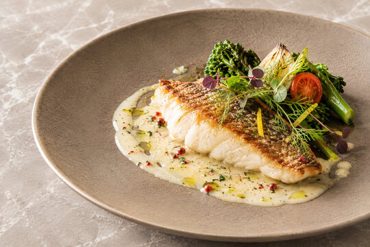 Pan-Seared Sea Bream with Herb Sauce and Green Vegetables on a Mocha Plate