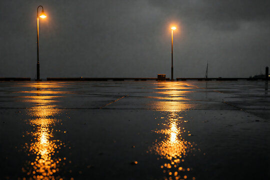Wet cobblestone pier reflecting street lamps at night