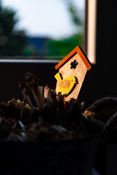 Small wooden birdhouse decoration illuminated by warm sunlight indoors