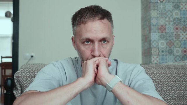 Man at home alone thinks through difficult decision, financial problems, unemployment and uncertain future while facing stress, doubt and personal crisis.