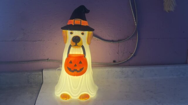 Cute Dog Holding a Lit Up Halloween Pumpkin Blow Mold Decoration With a Fun Spooky Holiday Theme