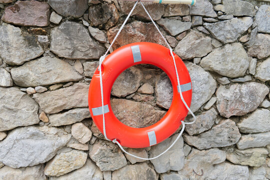 orange life preserver on a stone wall