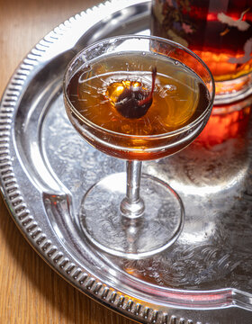 Manhattan cocktail with cherry splashing