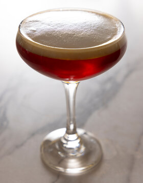 Foamy red drink in coupe glass