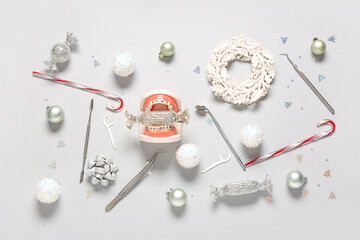 Fototapeta premium Dental health during holidays, orthodontic braces on teeth model with candy and dental tools for oral hygiene awareness in winter festive season