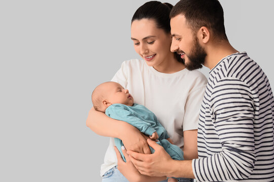 Parenthood and family bonding, happy young parents holding their newborn baby with love and care in a studio setting