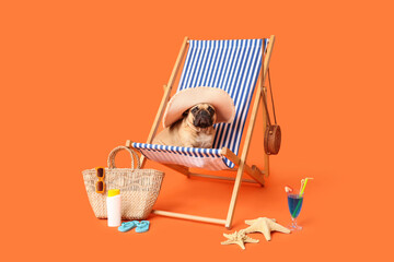 Fototapeta premium Summer vacation and travel concept, cute pug dog wearing sun hat sitting on a beach chair with tropical accessories on a bright orange background