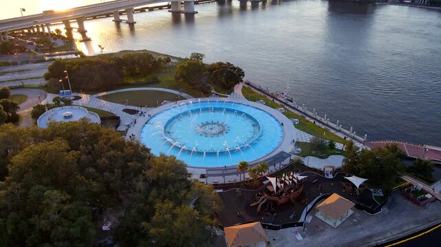 Smooth daytime drone footage shows fountain and St Johns River around Friendship Fountain in Jacksonville.
