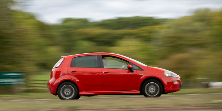 Milton Keynes; UK - Oct. 6th 2026: Red Fiat Punto Evo hatchback car driving on a British road