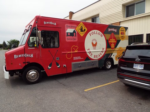 Gloucester, Ontario, Canada &ndash; July 31, 2026: A bright red "BeaverTails food truck" with custom branding is parked outside a commercial building on Canotek Road.