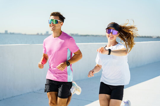 Joyful morning run along the coastal walkway with friends enjoying the sunshine