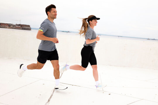 Morning joggers enjoy a refreshing workout along the coastal walkway during a cloudy day