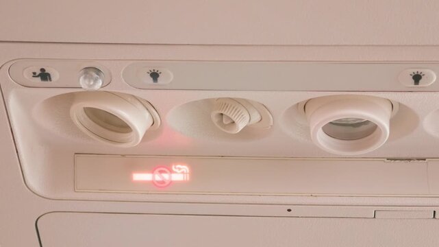 Airplane overhead console with no smoking sign and reading lights