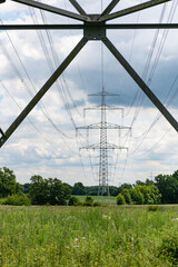 Fototapeta premium Electricity power lines in nature landscape. Green nature energy. Landscape of electric voltage station. High voltage. Electricity pylon. Nature summer environment. Electricity tower
