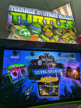 Teenage Mutant Ninja Turtles arcade game display at Oahu arcade center featuring character selection and gameplay options