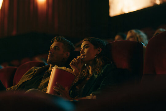 Young Couple Enjoying a Movie and Popcorn at the Cinema