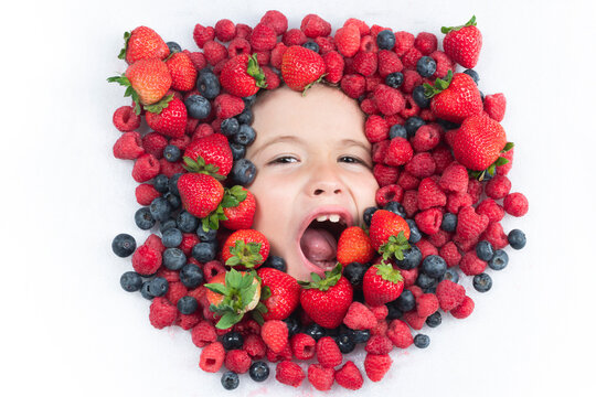 Berry banner. Assorted mix of strawberry, blueberry, raspberry, blackberry background. Berries closeup near kids face. Fresh berries, top view. Mix of raw fresh berries fruits.