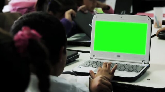 Unrecognizable Elementary Student Using Small Laptop with Green Screen in Public School Classroom - 4K