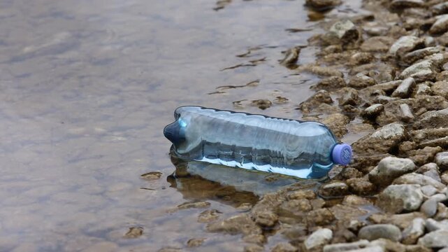 Environmental pollution, Plastic bottle washed up on the lake shore, Austria