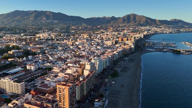 Aerial View of Fuengirola Coastline Panning Toward Marina with Boats, Beach and Mountain Backdrop, Costa del Sol, Malaga, Spain