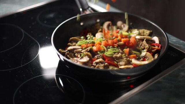 Carrots and peas fall into a pan with mushrooms and soy pieces