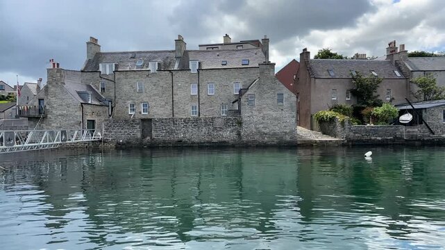 Small harbour with jetty, boat and stone buildings in the background, quiet and peaceful atmosphere, Lerwick, Shetland Islands, Scotland, United Kingdom