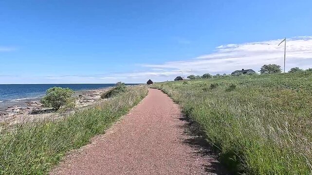 A lonely path leads along the coast with a view of the blue sea under clear skies, Byxelkrok, &Ouml;land, Sweden