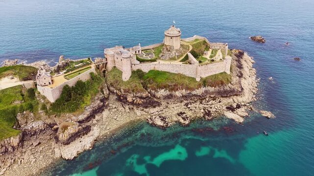 Aerial view of the historic rock castle Fort la slat, Ch&acirc;teau de la Roche Goyon on a rocky headland on the Emerald Coast, surrounded by the turquoise Atlantic Ocean, Plevenon, C&ocirc;tes-d'Armor departm