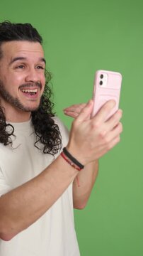 Young man expressing emotions during video call on green screen