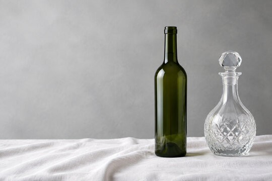 Empty wine bottle with crystal decanter on linen, beverage service and elegance concept