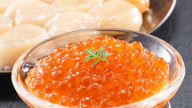 Golden salmon roe cured in soy marinade presented in elegant glass bowl with herb garnish
