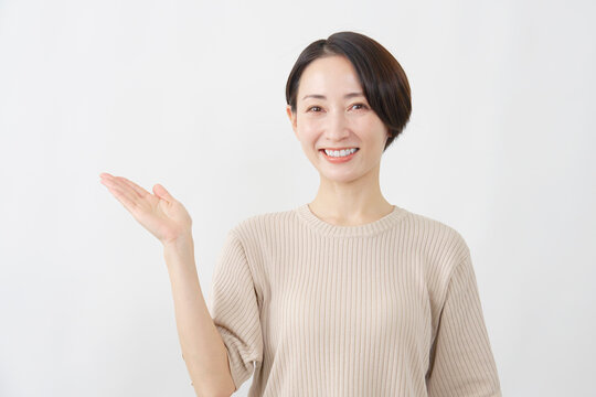 手のひらで左を案内する女性　白背景