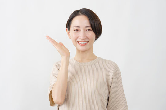 手のひらで左を案内する女性　白背景