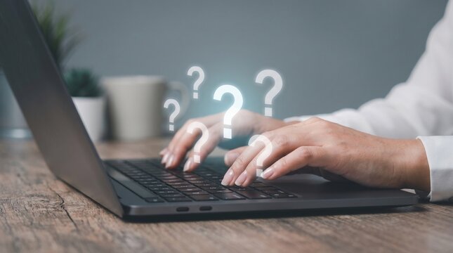 Person typing on laptop keyboard with glowing question marks floating above