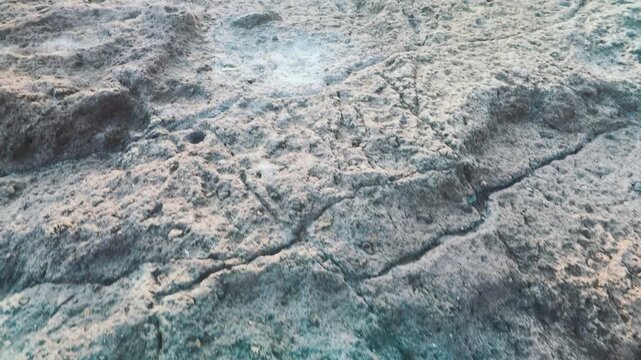 Cinematic aerial drone view of rough rocky coastal cliff edge with crashing ocean waves