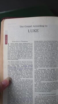 Opening to the book of Luke of the New Testament in the Holy Bible. New Revised Standard Version. Vertical video.