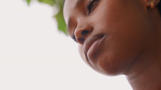 Close up portrait captures lower half of woman face focusing on her lips and jawline. soft lighting highlights natural skin texture while woman maintains slight facial expressions