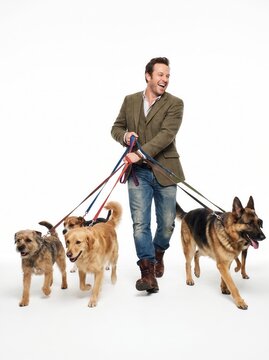 Happy mature man walking multiple dogs on leashes against a white background123