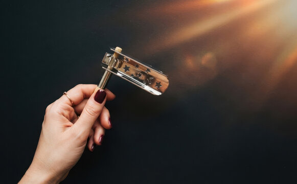 Woman holding traditional wooden Hanukkah grogger noise maker toy on dark background