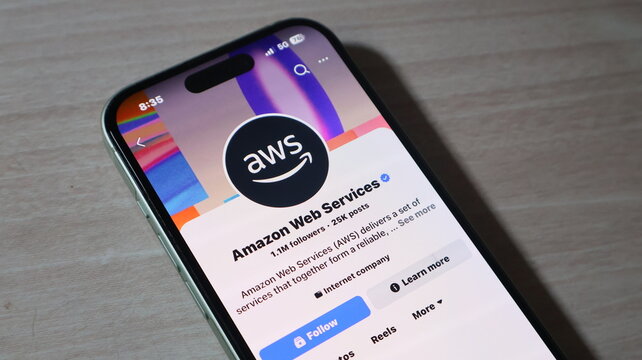 Handheld smartphone showcasing amazon web services profile with blue accent colors for cloud computing business news.