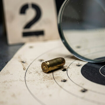 Crime scene investigation bullet casing on target magnifying glass and evidence marker