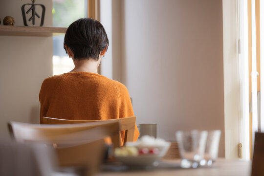 更年期の気分の落ち込みや秋冬の季節性うつに悩む日本人女性の後ろ姿、孤独感や無気力、憂鬱な気分、ホルモンバランスの変化とメンタルヘルスの不調を表現するイメージ顔無しの後姿