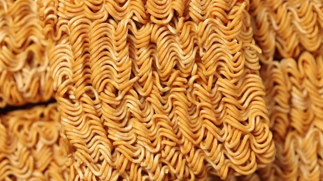 Close-up shot of wavy instant noodle texture slowly rotating. Top view
