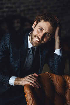 Idea for male wedding photoshoot. Groom in a white shirt, blue suit posing in a loft interior for wedding photo session. Sexy gorgeous handsome young confident fit slim man in casual clothing