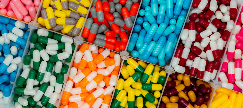 Pharmaceutical capsules sorted by color in organizer tray, medicine and healthcare background. Pharmacy, medication management, drug manufacturing and pharmaceutical industry. Pharmacy inventory.